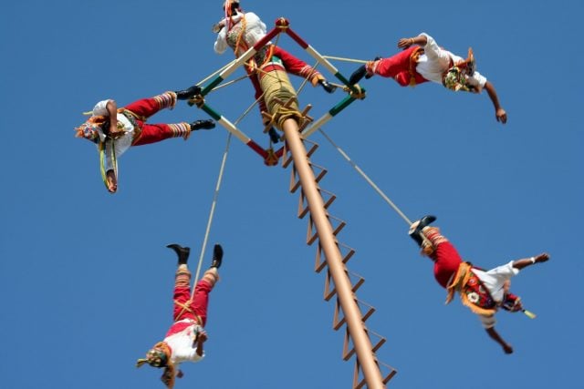 Se ven a varios voladores de papantla empezando a girar