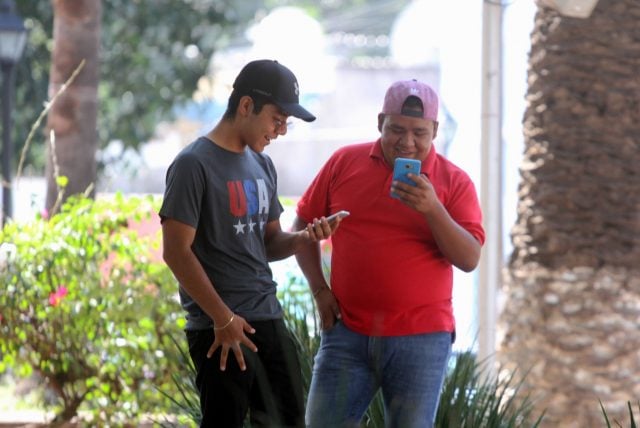 Jóvenes con celulares en la calle