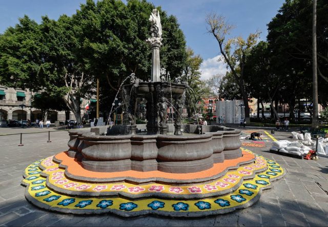 Artesanos de Tlaxcala decoran con alfombra monumental la Fuente de San Miguel, en el Zócalo de Puebla